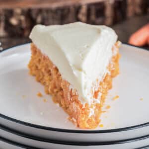 A slice of carrot cake on a white plate.