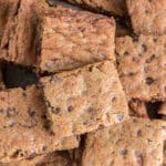 Nutty chocolate chip bars on a sheet of parchment paper.
