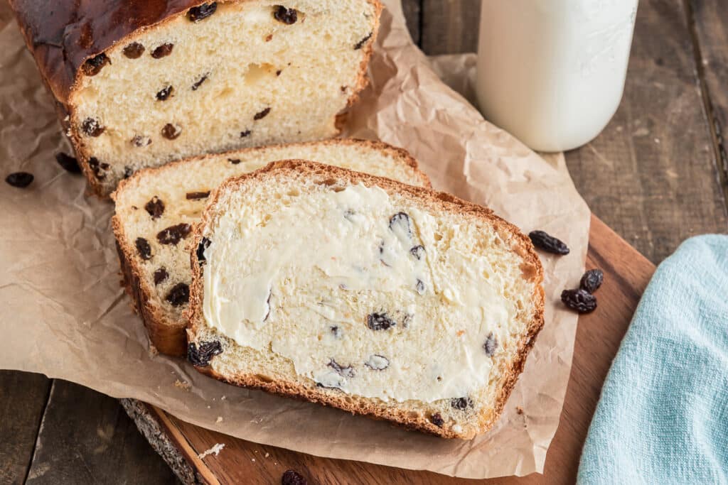 Sliced raisin bread with butter on it.