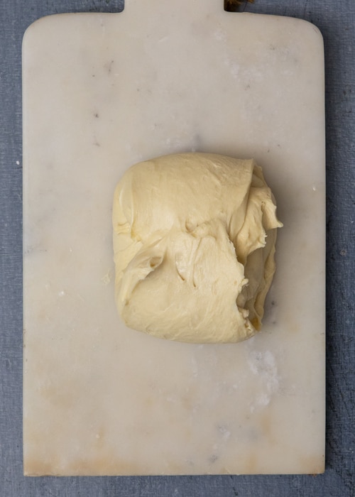 The dough folded on a wooden board.