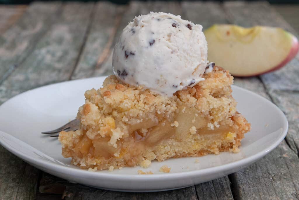 A slice of cake with a scoop of ice cream on top.