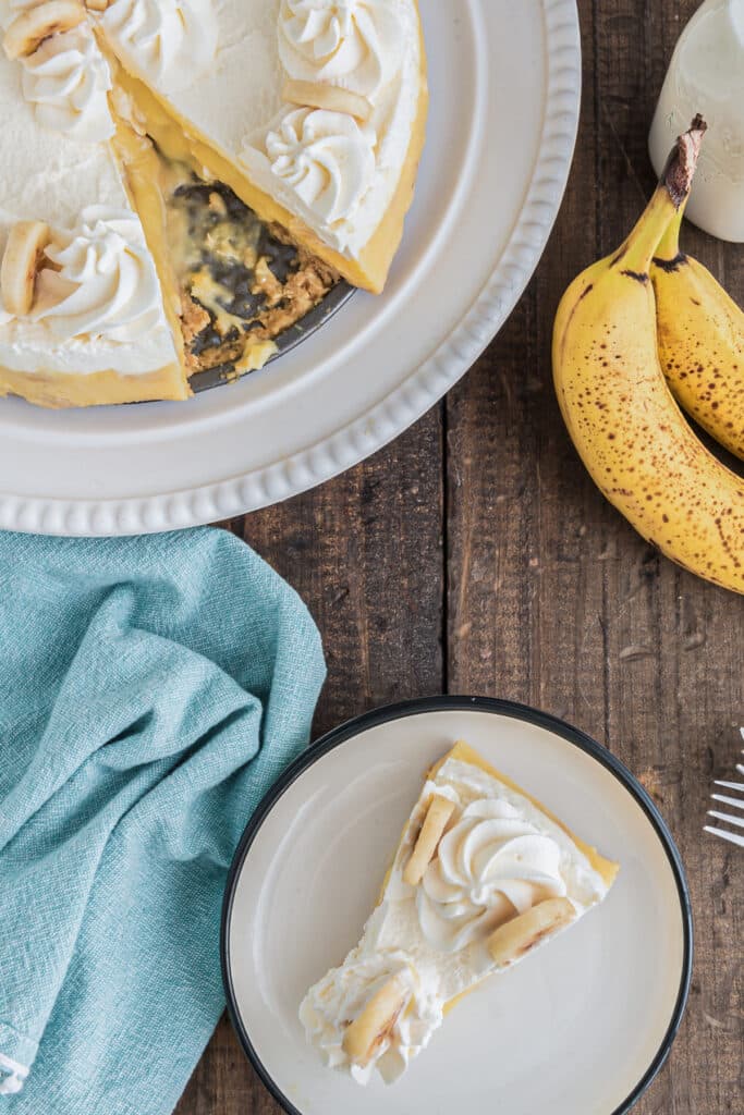Banana cream pie with a slice on a white plate.