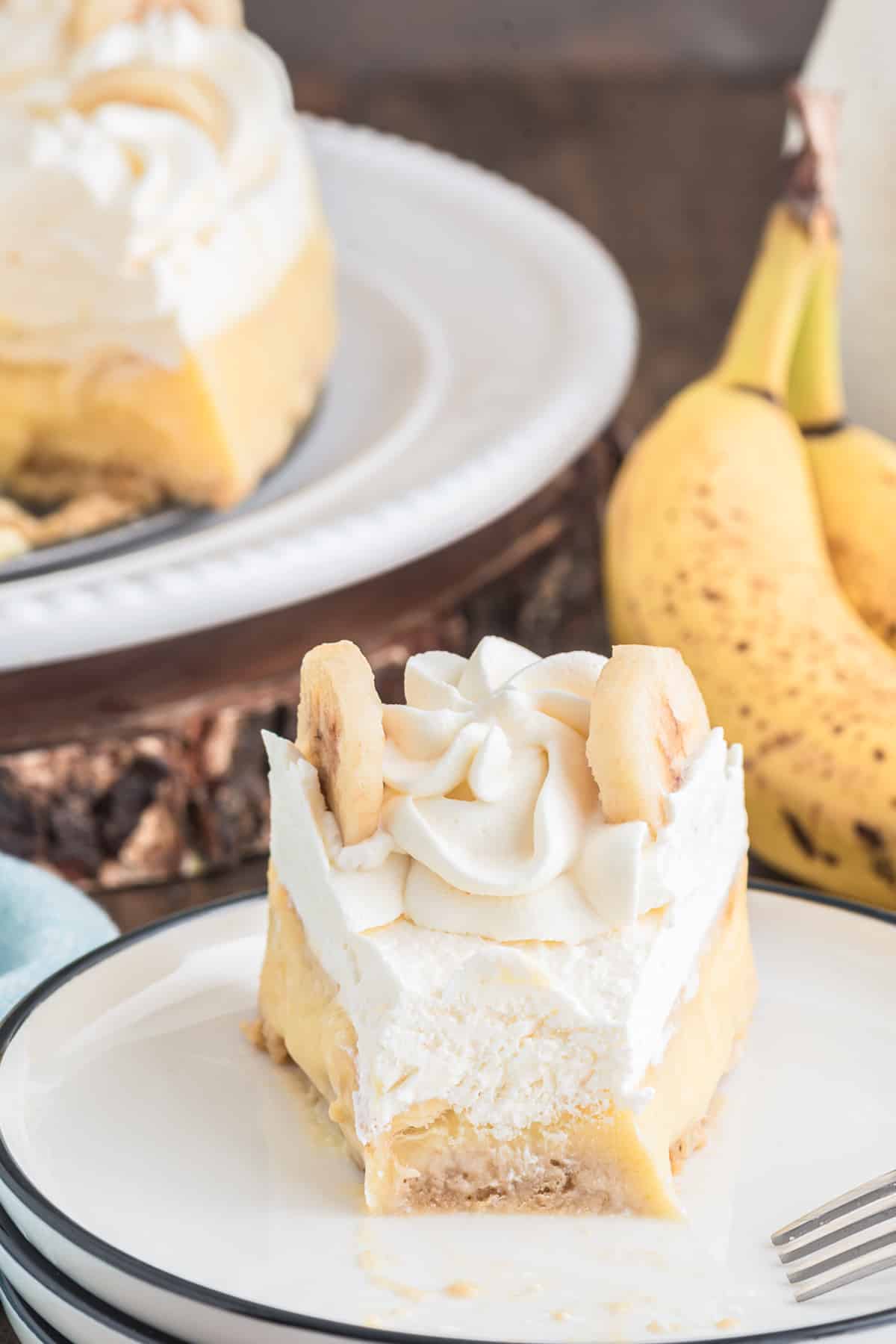 Pie on a white plate with a slice on a small white plate with a small piece cut.