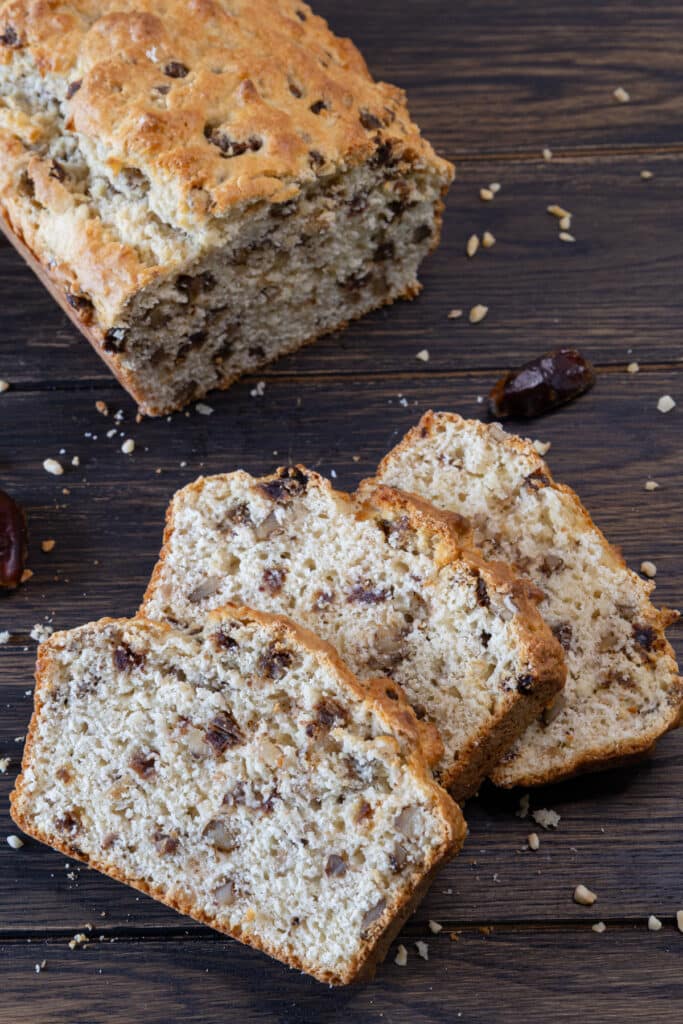 Date and nut loaf with three slices cut.