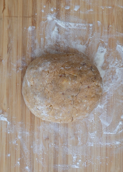 Forming the dough into a ball on a wooden board.