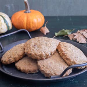 Pumpkin cookies on a black pan.