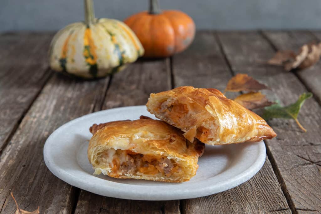 A cut hand pie on a white plate.