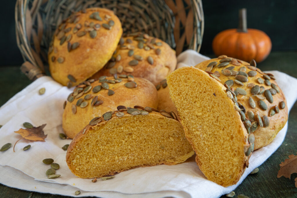 Pumpkin buns with one cut in half.