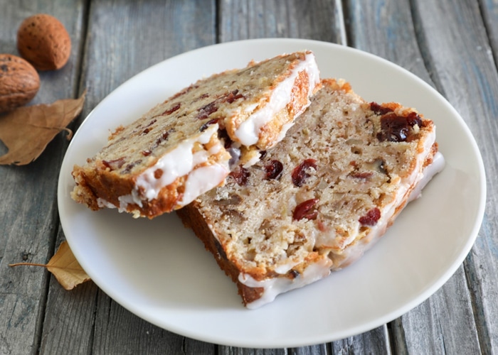 Two slices of cranberry nut bread on a white plate.