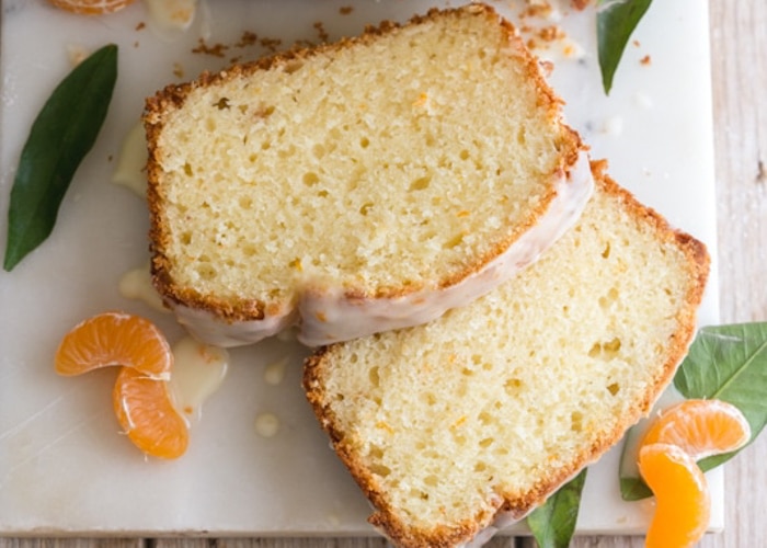 Two slices of mandarin orange bread on a white board.