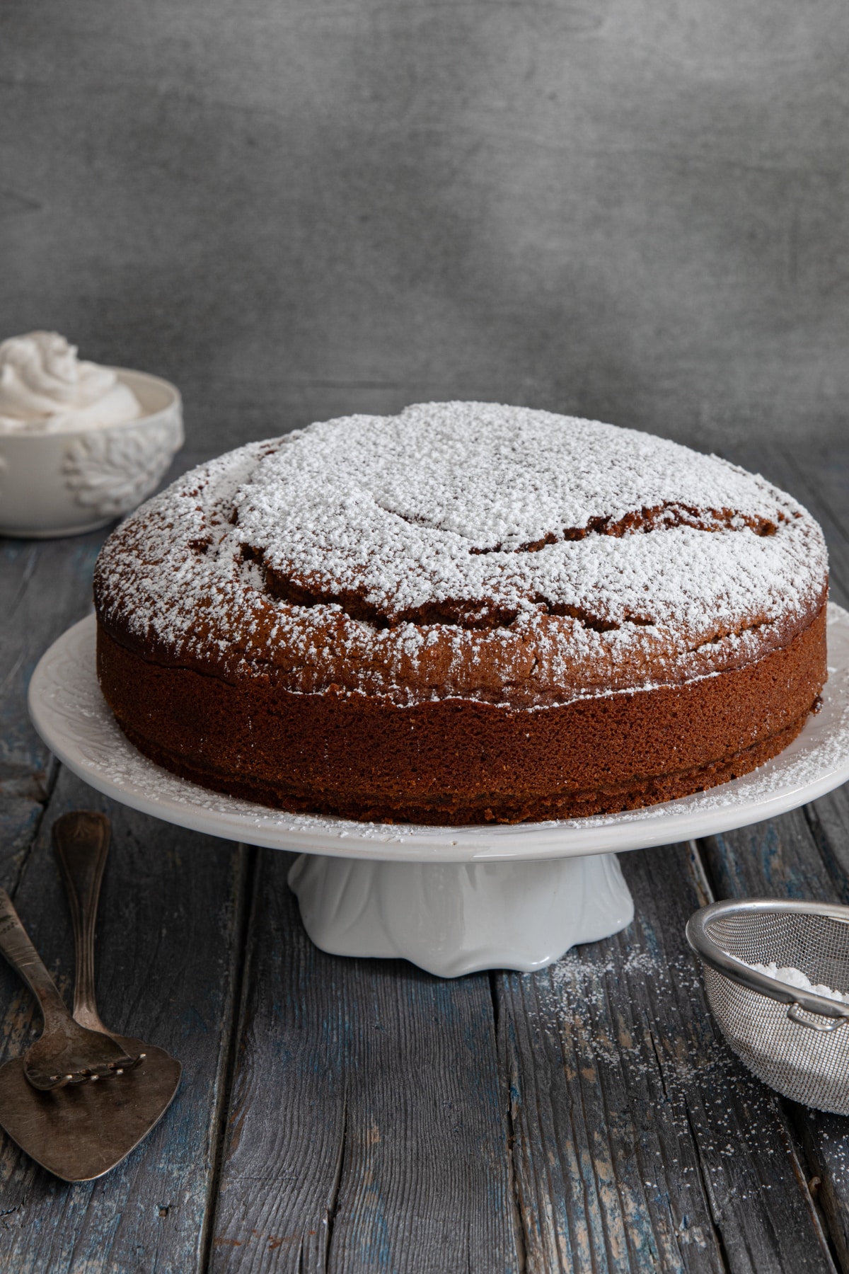 Gingerbread cake on a white cake stand.