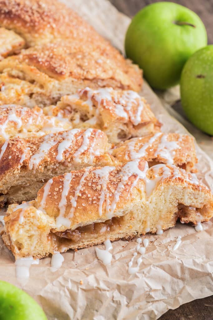 Braided apple bread with three slices cut.