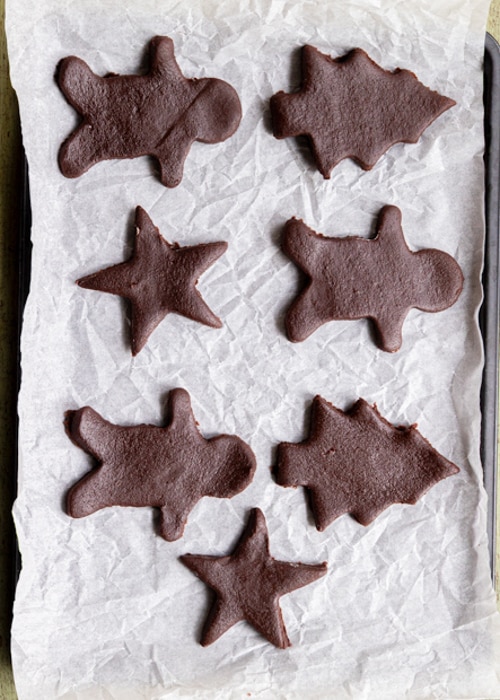 The cookies cut out on a baking sheet.