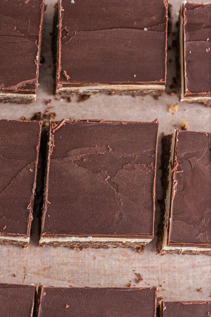 Nanaimo bars cut on parchment paper.