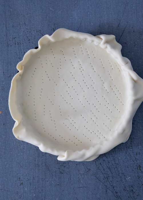 Pie crust in the pan and pricked.