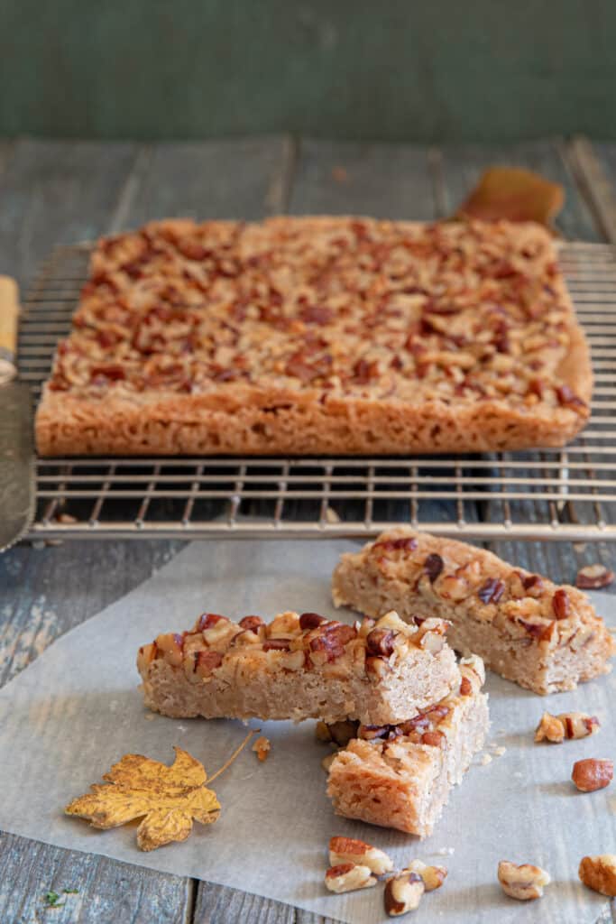 Pecan stick on a wire rack and three on a piece of parchment paper.