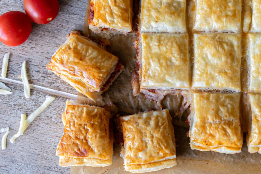Puff pastry appetizers cut on a board.
