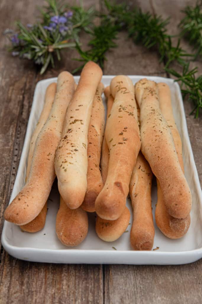 Bread sticks on a white dish.