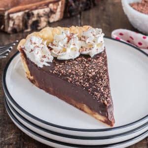 A slice of chocolate cream pie on a white plate.