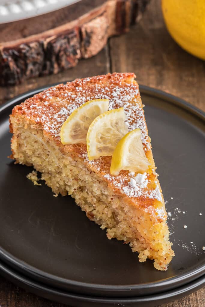 A slice of cake on a black plate.