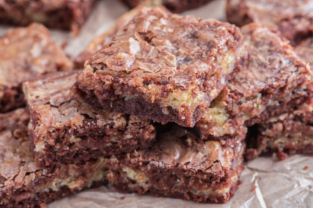 Brownies stacked on paper.