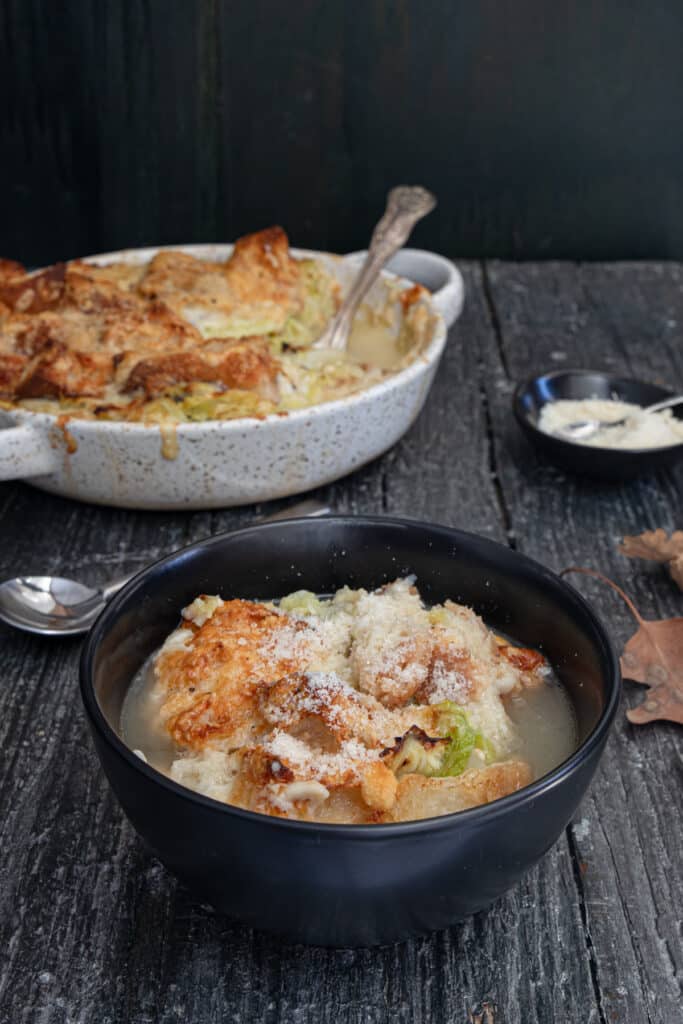 Cabbage soup in the pan and in a black bowl.