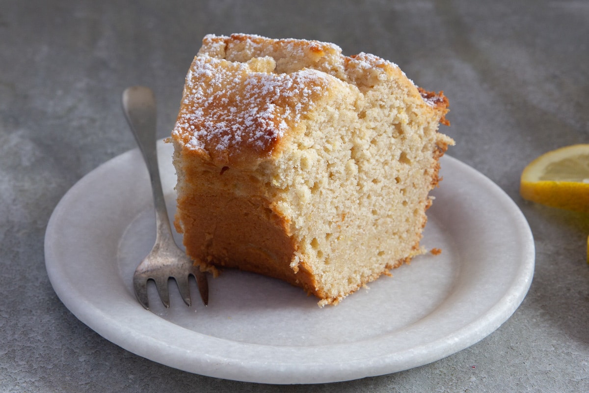 A slice of ricotta cake on a white plate.