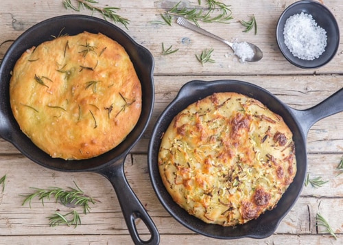 Focaccia bread in two black pans.