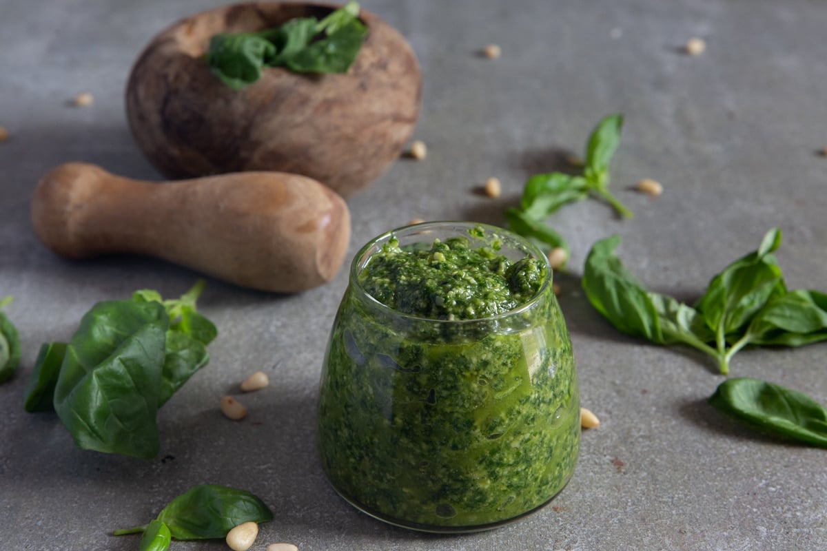 Basil pesto in a small glass jar.