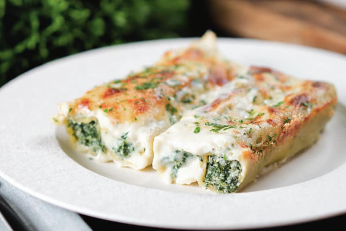 Two cannelloni on a white plate.