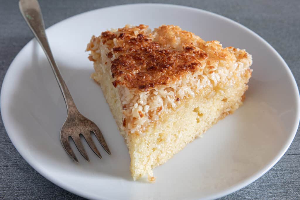 A slice of cake on a white plate.