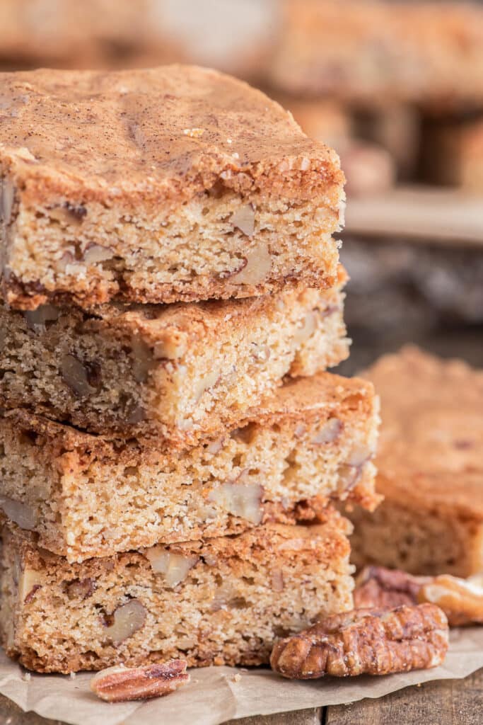 Four pecan blondies stacked.