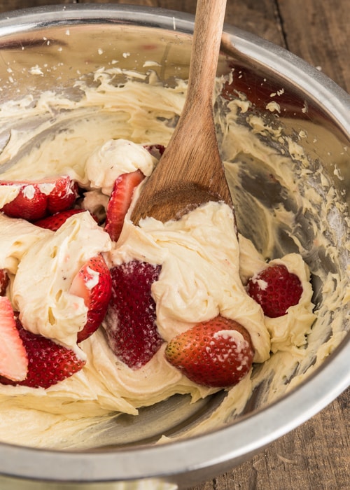 Adding the strawberries to the batter.