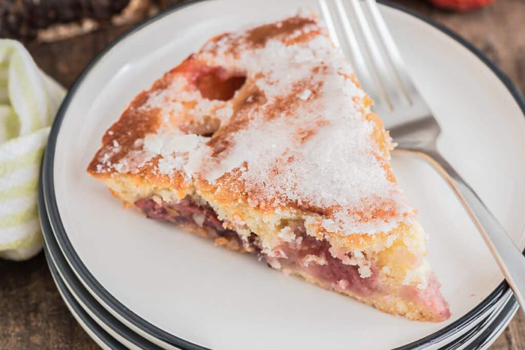 A slice of strawberry cake on a white plate.