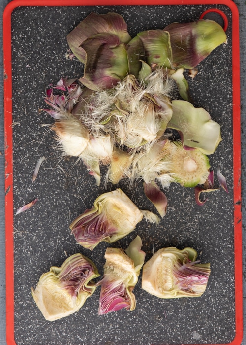 Cleaning the artichokes on a black board.