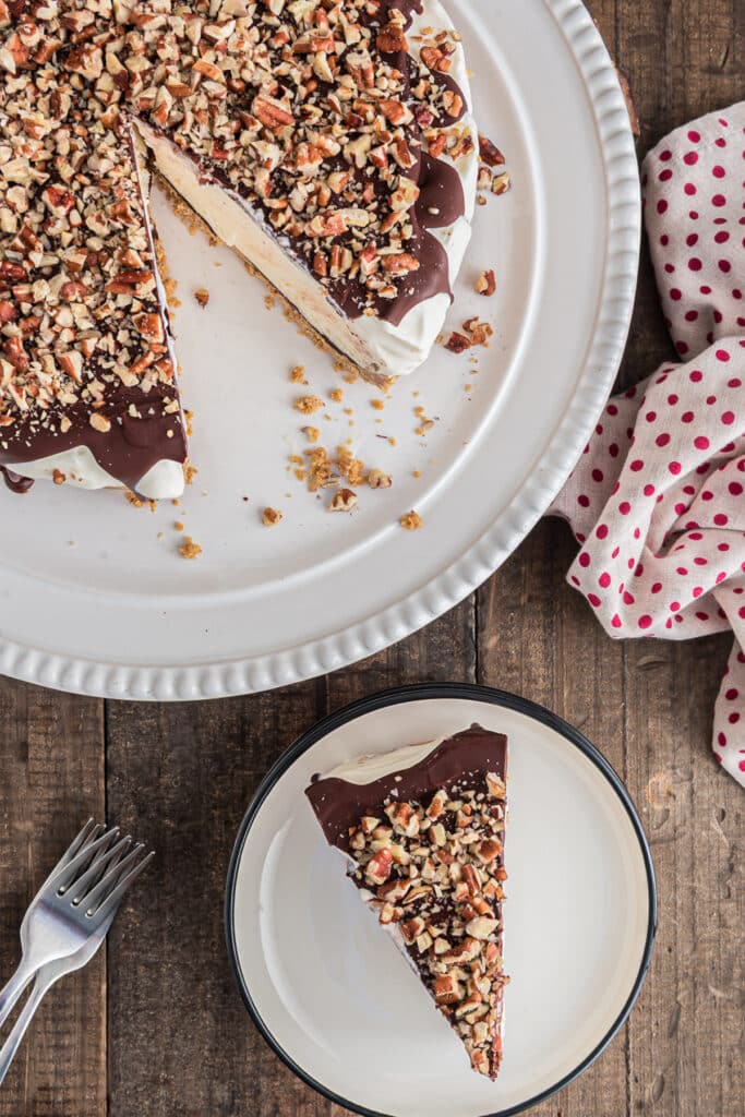 The ice cream cake on a white plate and a slice on a small white plate.