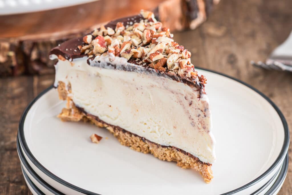 A slice of ice cream cake on a white plate.