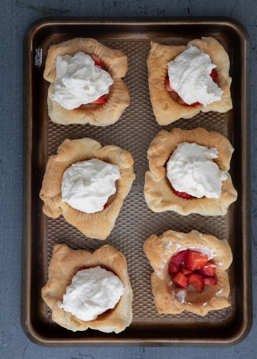 The cut strawberries and filling in the baked cups.