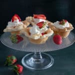 Strawberry cups on a glass cake stand.