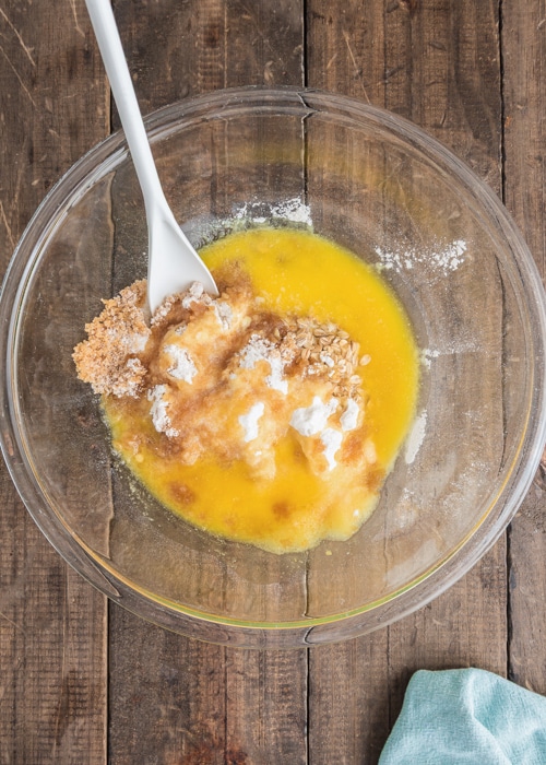 Mixing the crumbs and butter in a glass bowl.