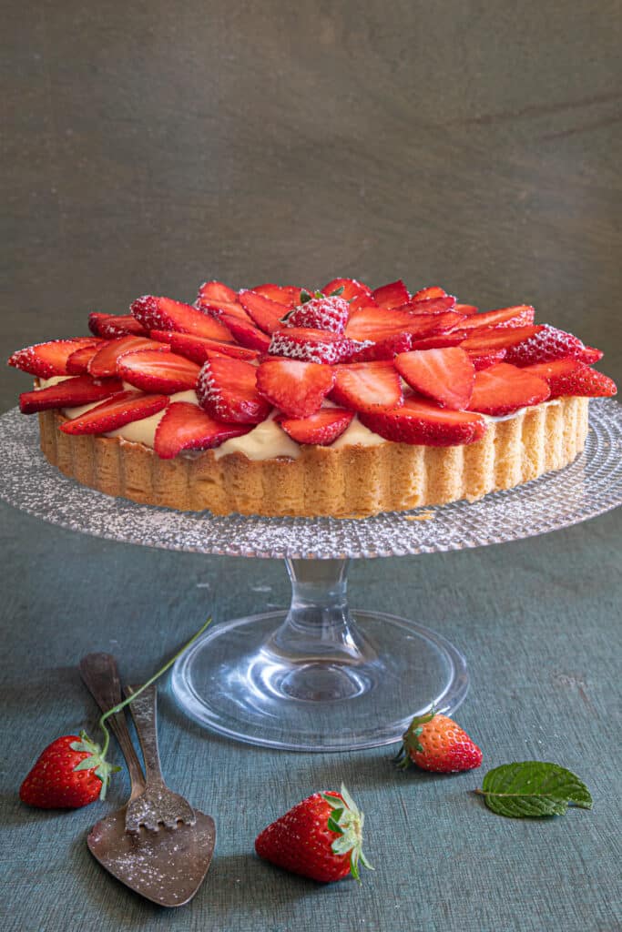 Strawberry crostata on a glass cake stand.