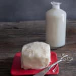 Butter in a red dish with a silver knife.