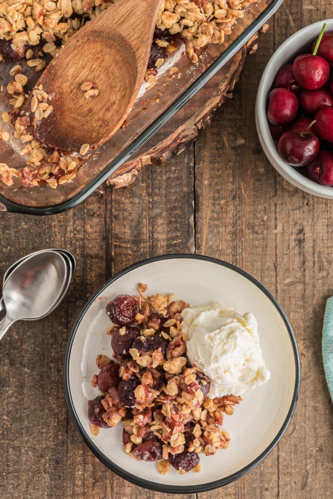Crumble in a glass pan and some on a plate with ice cream.