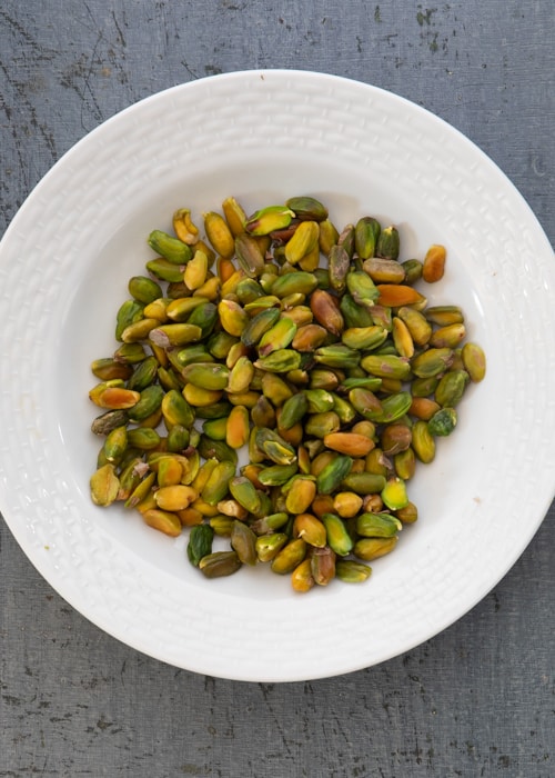 Pistachios in a white bowl.