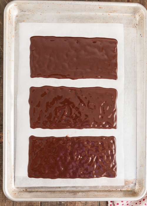Spreading the chocolate evenly on the rectangles.
