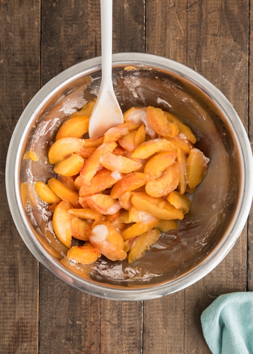 Mixing the sliced peaches and sugar.