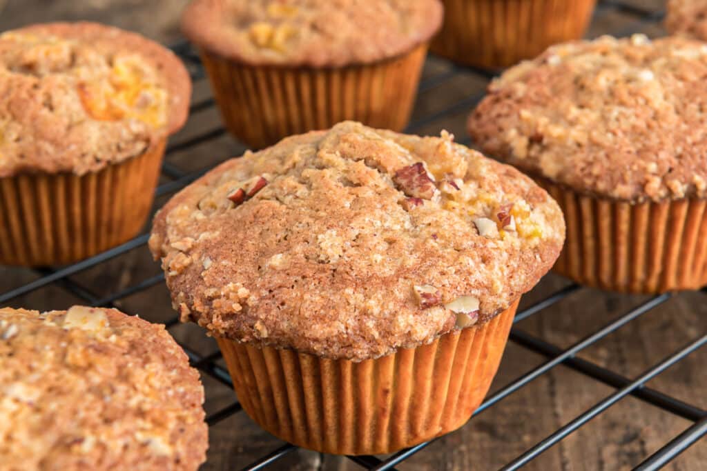 Peach muffins on a wire rack.