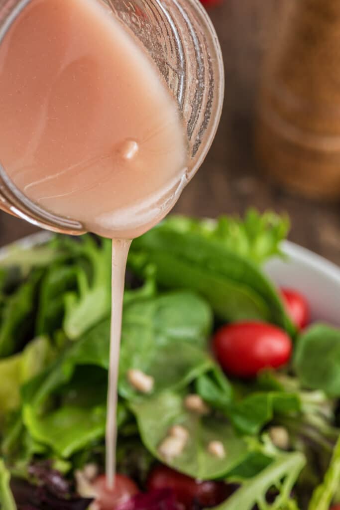 Pouring the dressing into a salad.