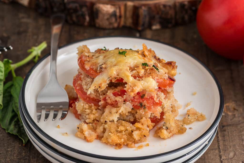 A slice of tomato casserole on a white plate.