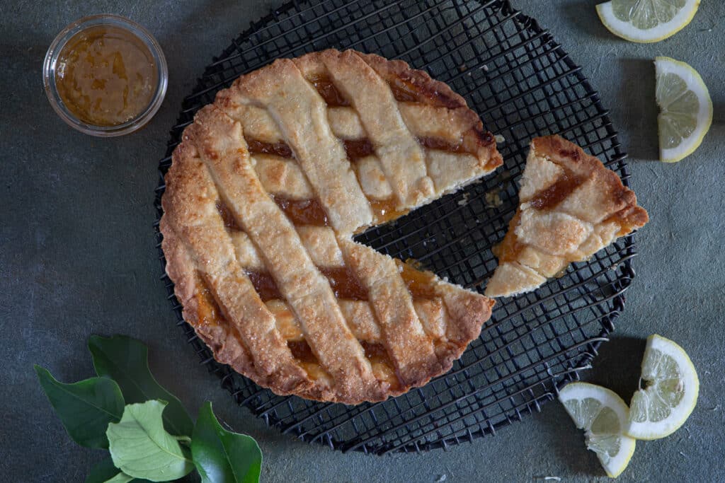 Crostata made with lemon marmalade with a slice cut.